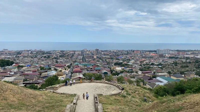 Панорама Дербента со смотровой площадки: черепичные крыши старого города спускаются к Каспийскому морю, вдали новостройки