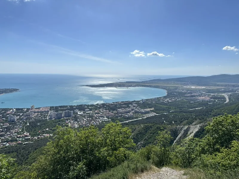 Геленджик: панорама Геленджикской бухты сверху — город, порт и море в ясную погоду, вид с горного склона.