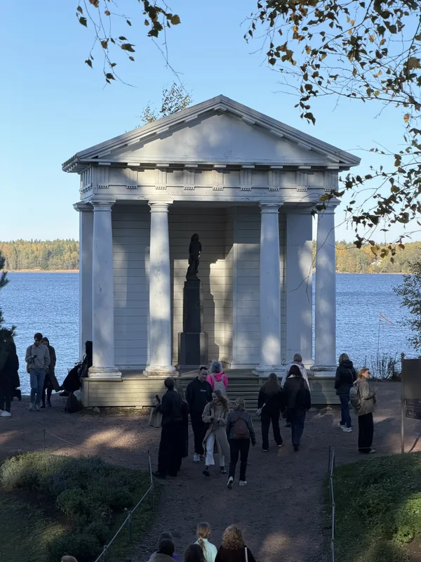 Храм Нептуна на берегу бухты, у павильона посетители