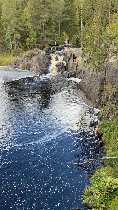 Порог Ахвенкоски сверху: рыжая от торфа вода падает по гранитным уступам в тёмную заводь