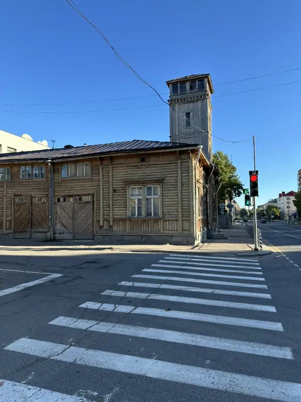 Старое деревянное здание с высокой дощатой башней на перекрёстке в Сортавале