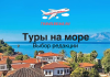 Туры на море — Выбор редакции Travel banner for TRAVELBELKA.RU featuring a coastal town with red-roof houses, blue sea and mountains; text reads 'Туры на море' and 'Выбор редакции'.